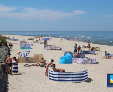 Plaża w Jastrzębiej G&oacute;rze i charakterystyczny kilometrowy mur oporowy zbudowany z olbrzymich głaz&oacute;w.